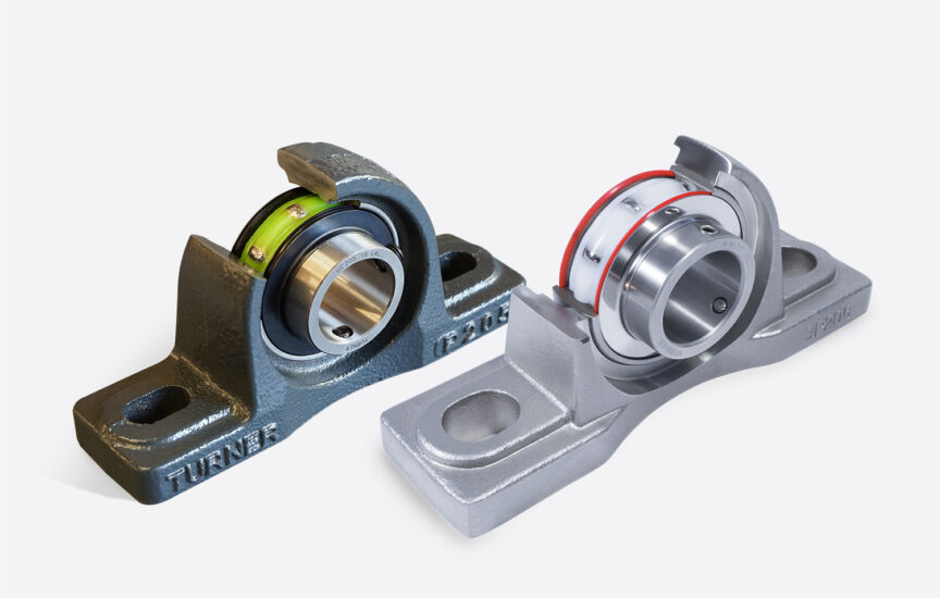 A photo of two mounted bearing units. The housings are cut away to show the solid lubrication inside of the bearings.